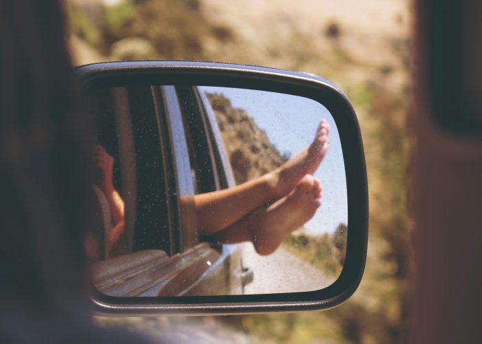 Forfait Relax – La Sérénité avec la Conciergerie Émilie Coudenneau Illustration de la Prestation Forfait Relax de la Conciergerie Émilie Coudenneau à Bordeaux, avec un rétroviseur montrant des pieds détendus à l’extérieur d’une voiture.
